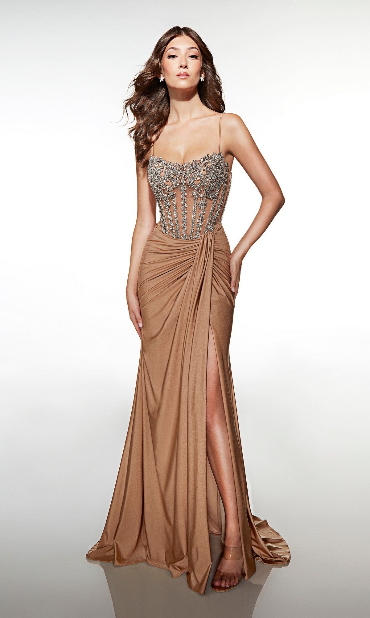 A woman in the Alyce 62123 long tan prom dress, featuring a sleeveless beaded corset bodice and a high-leg slit, stands against a plain white background.